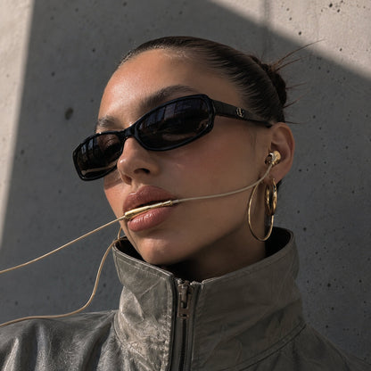 Gold chrome earbuds worn outdoors